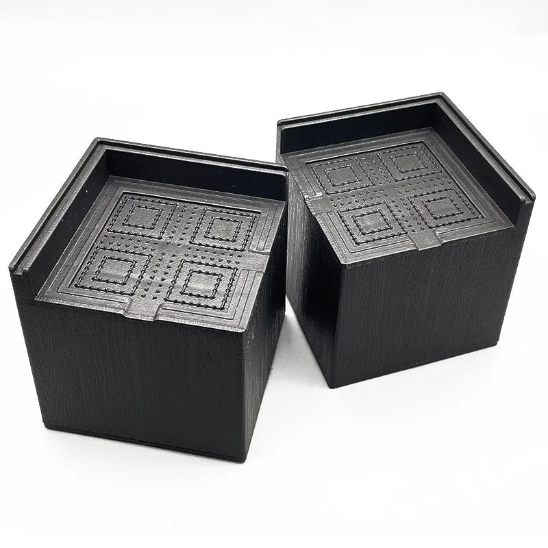 Four black plastic bed foot mats for sofa height increase on hard flooring
