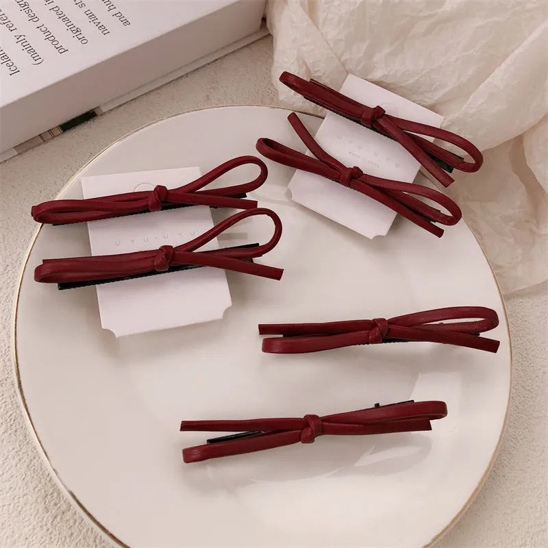 Wine red leather bow barrette hair clip for women showing manual crafted detail