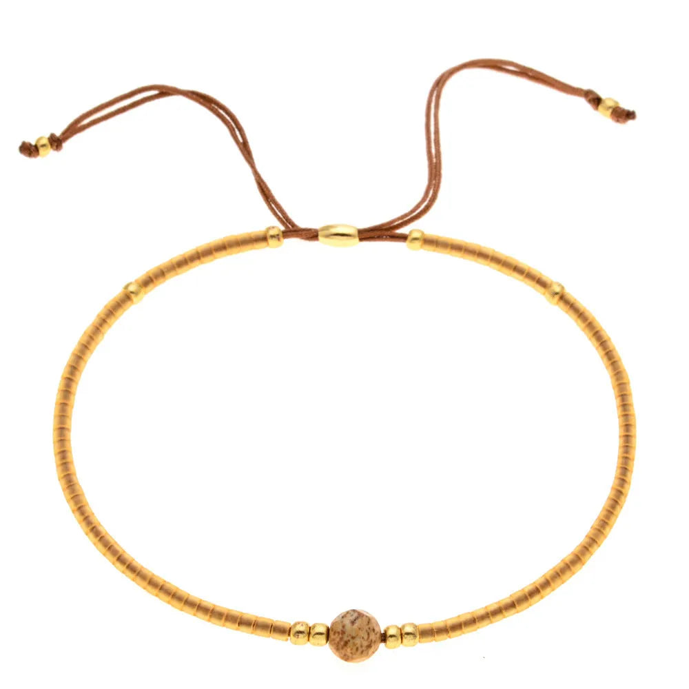 Handmade bohemian bracelet with colourful semi-precious stones and glass beads in geometric patterns.
