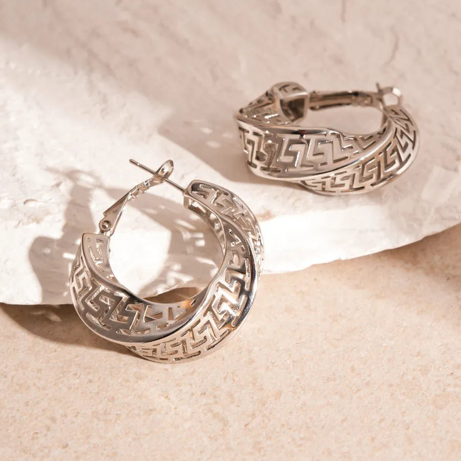 Geometric round hollow stud earrings for women with a twisted design in gold or silver finish.