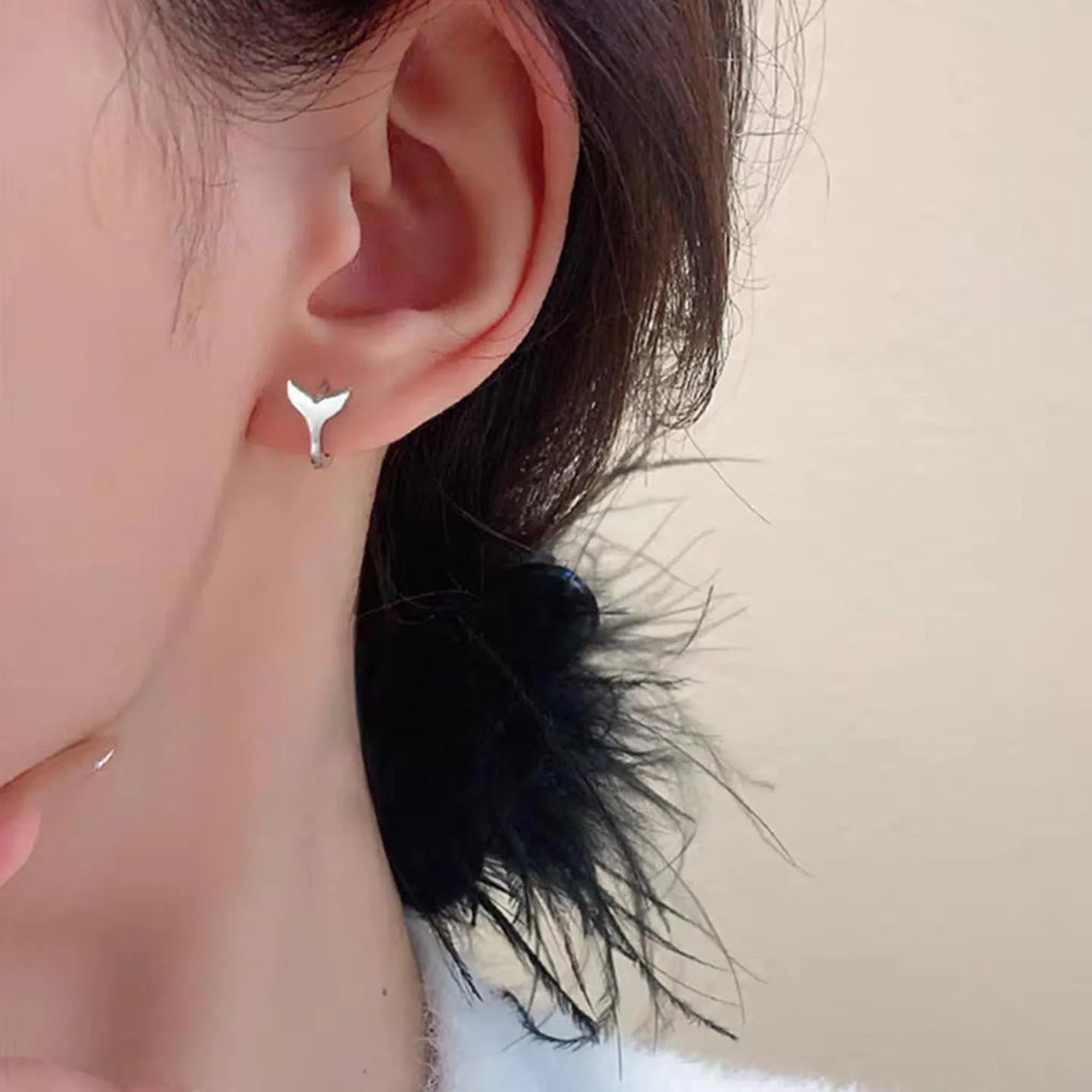A pair of simple fishtail design earrings with a metallic electroplated finish in either white gold or yellow gold colour.