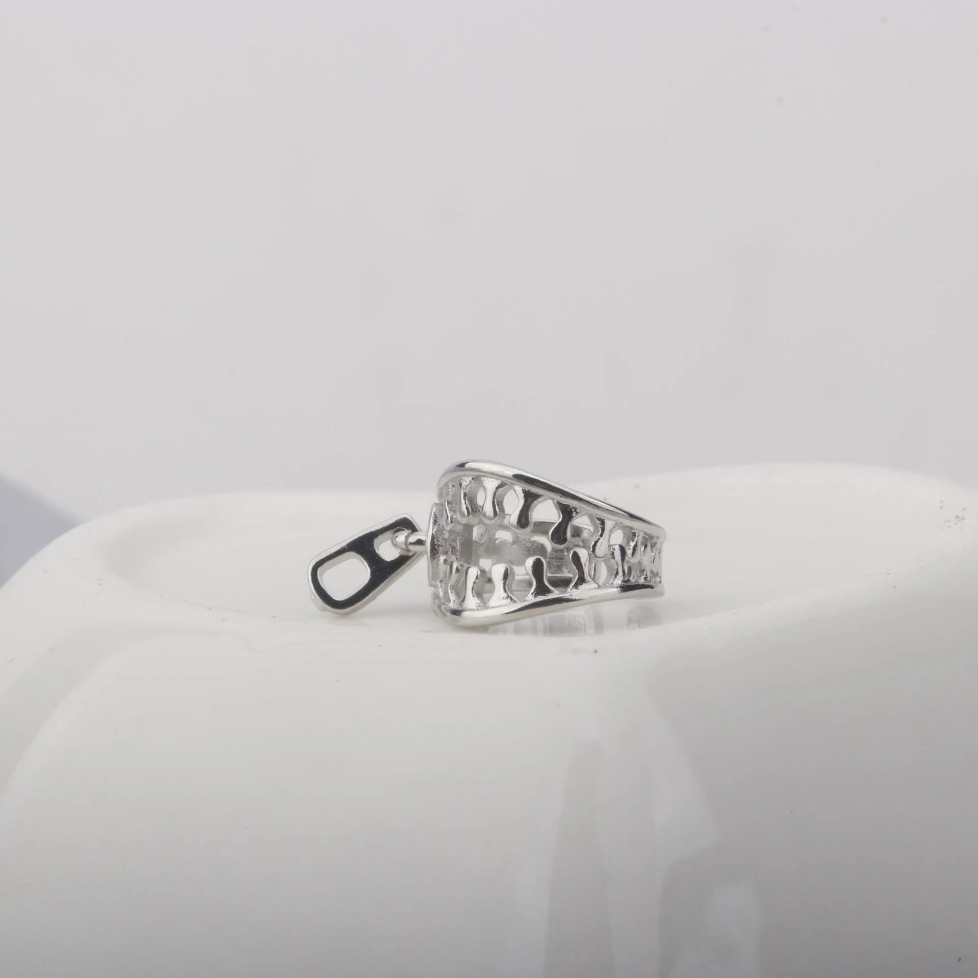 A pair of geometric-shaped copper ear clips with a zipper design detail, colour ES862.