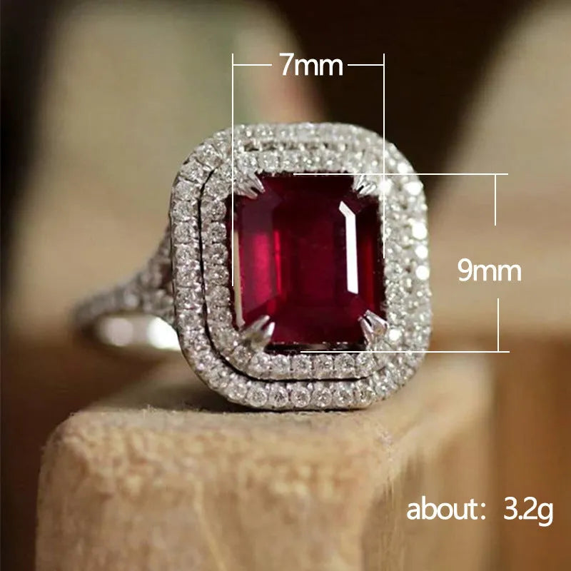 Women's copper square ring with red finish and a central rhinestone, showing geometric design.