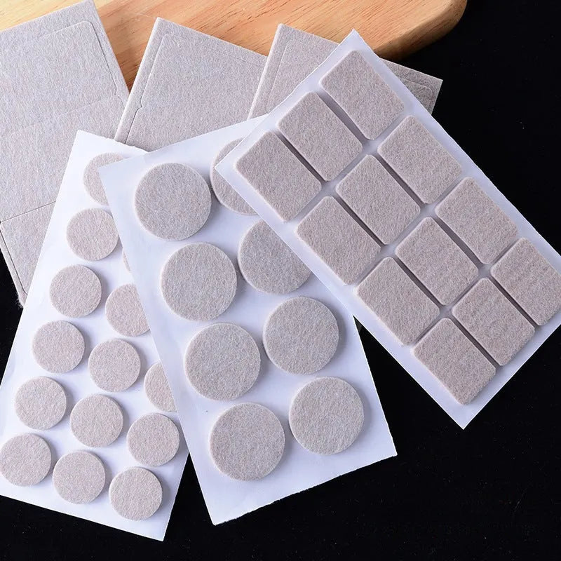 Assortment of beige plastic furniture leg protector pads in round and square shapes on a floor