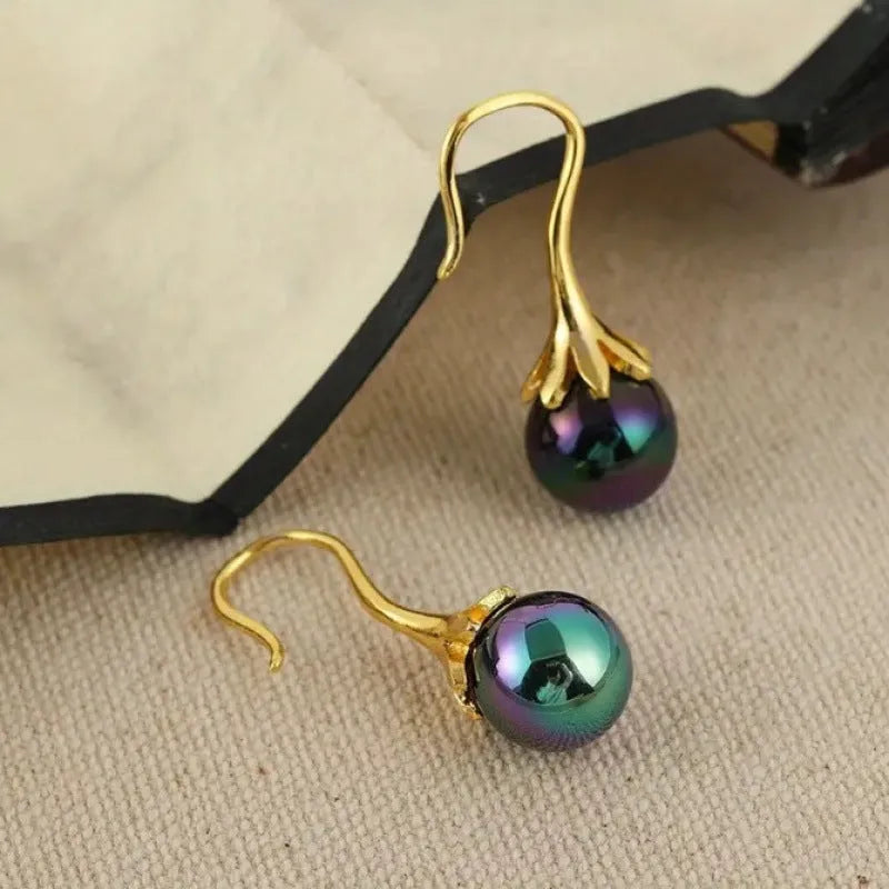 Pair of retro-style gold-coloured fashion earrings for women with creative design.