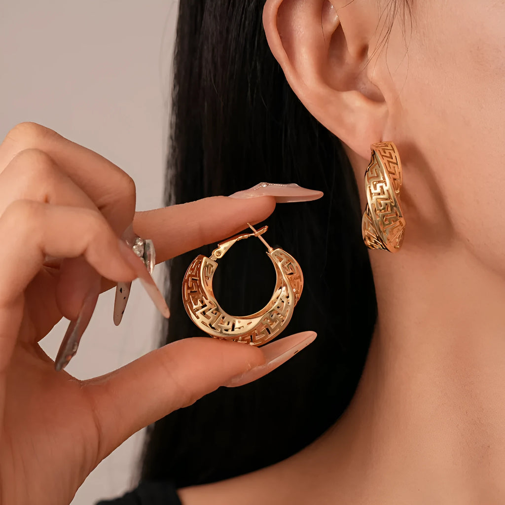 Geometric round hollow stud earrings for women with a twisted design in gold or silver finish.