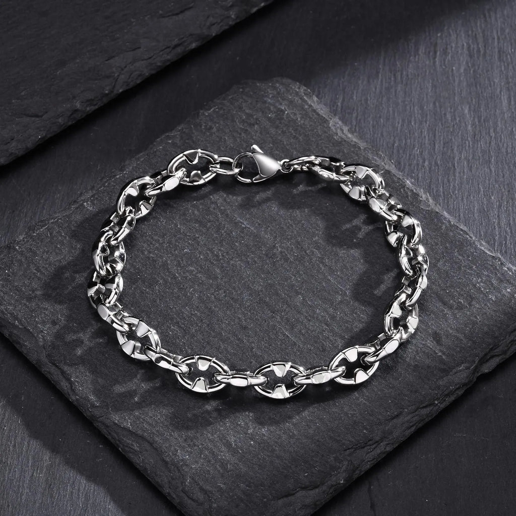 A thick, geometric stainless steel chain bracelet shown on a wrist, highlighting its handmade links and steel colour.