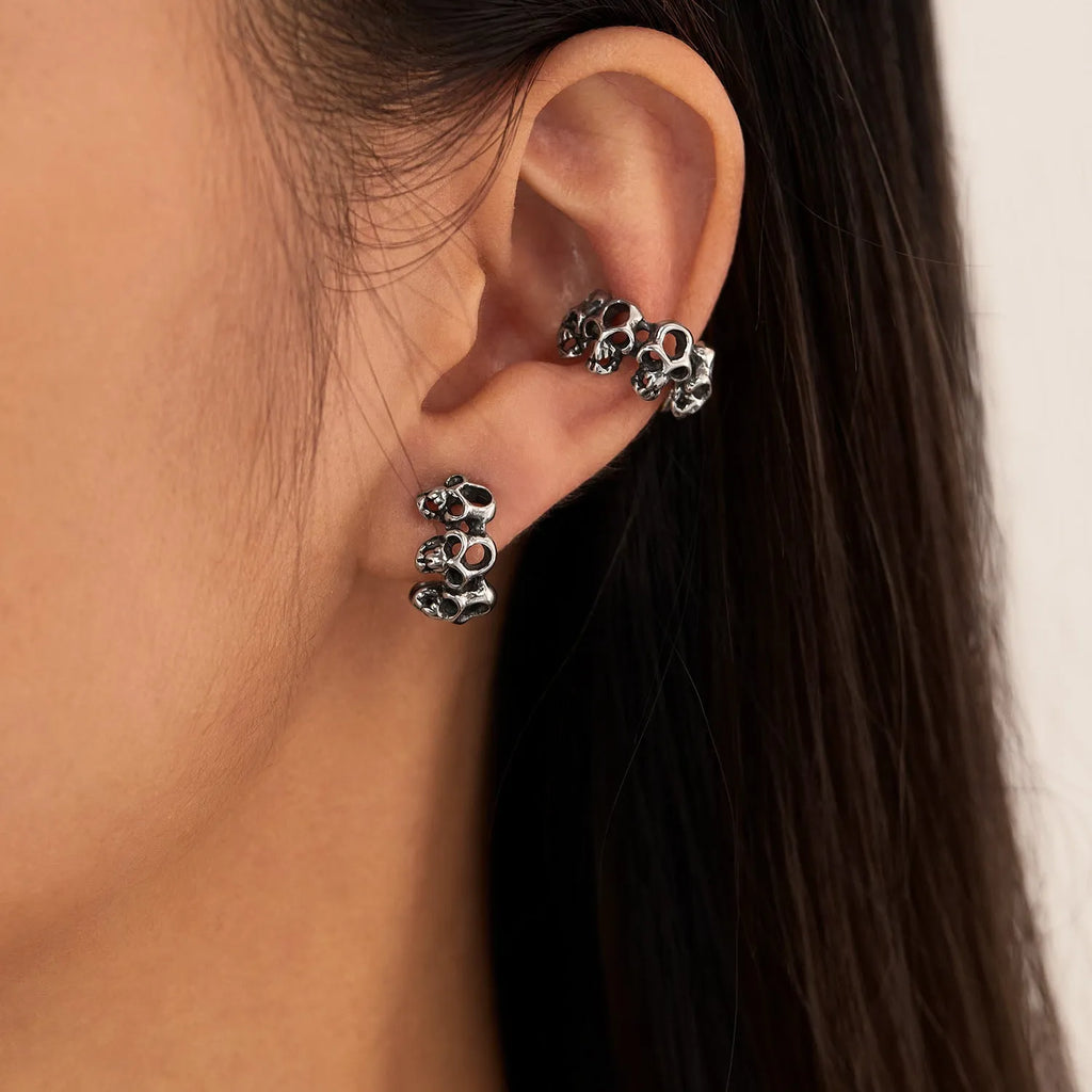 Stainless steel hollow skull ear clips with geometric design and steel colour finish