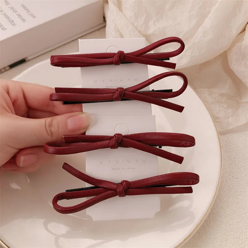 Wine red leather bow barrette hair clip for women showing manual crafted detail