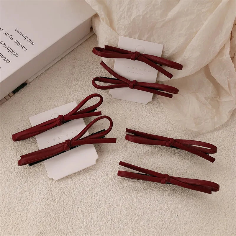 Wine red leather bow barrette hair clip for women showing manual crafted detail