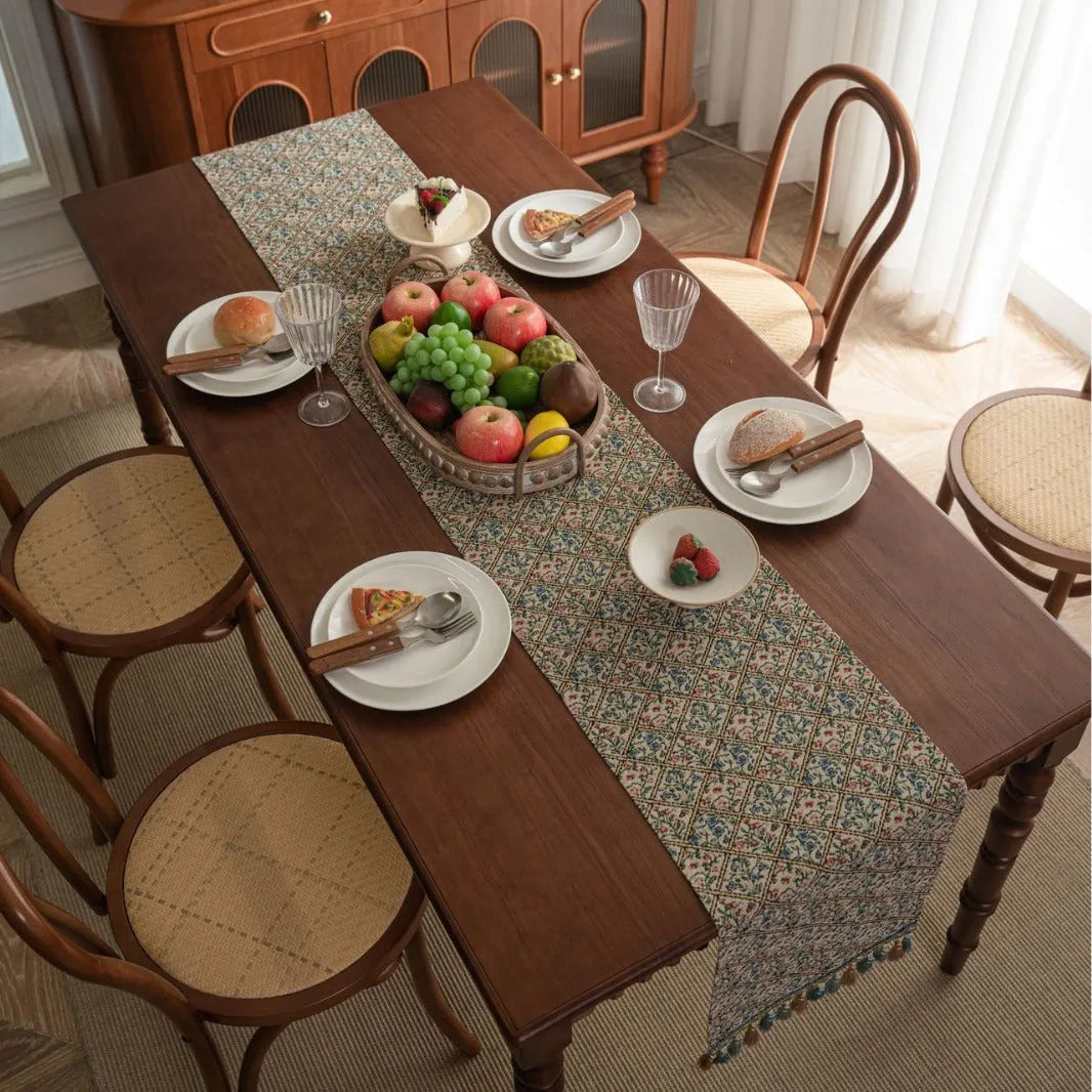Rhyme Nordic jacquard table runner with tassel trim in a striped pattern, laid flat on a wooden table.