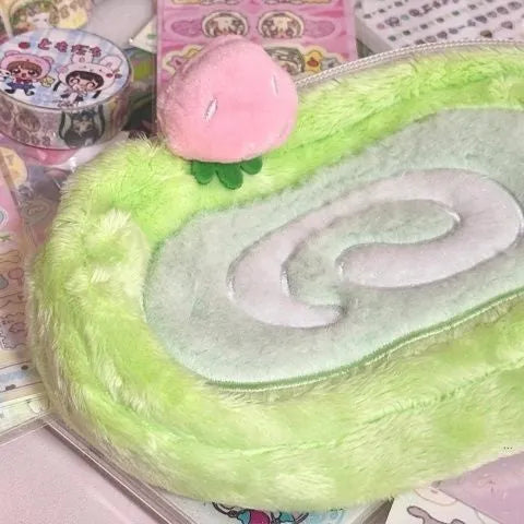 Soft velvet pencil case with Swiss roll cake design, rolled up.