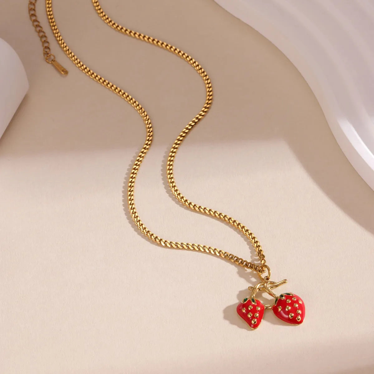Stainless steel strawberry fruit pendant necklace for women showing red and white gradient colour options