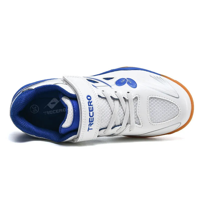 White and blue low-top badminton shoes with a ribbed sole and casual round-toe design on a court surface.