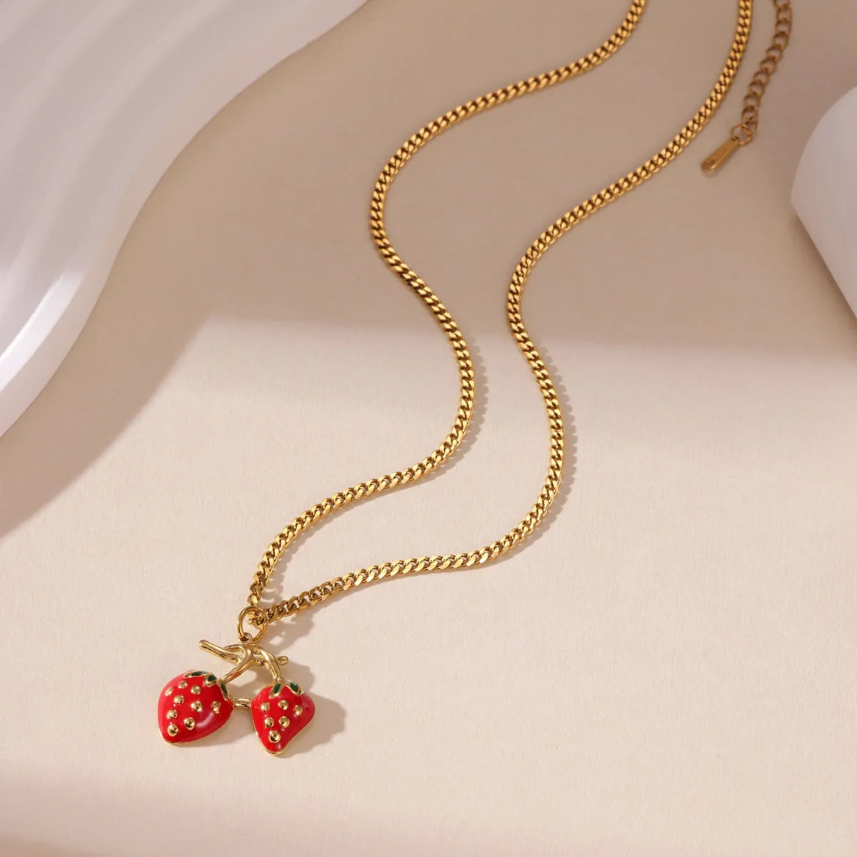 Stainless steel strawberry fruit pendant necklace for women showing red and white gradient colour options