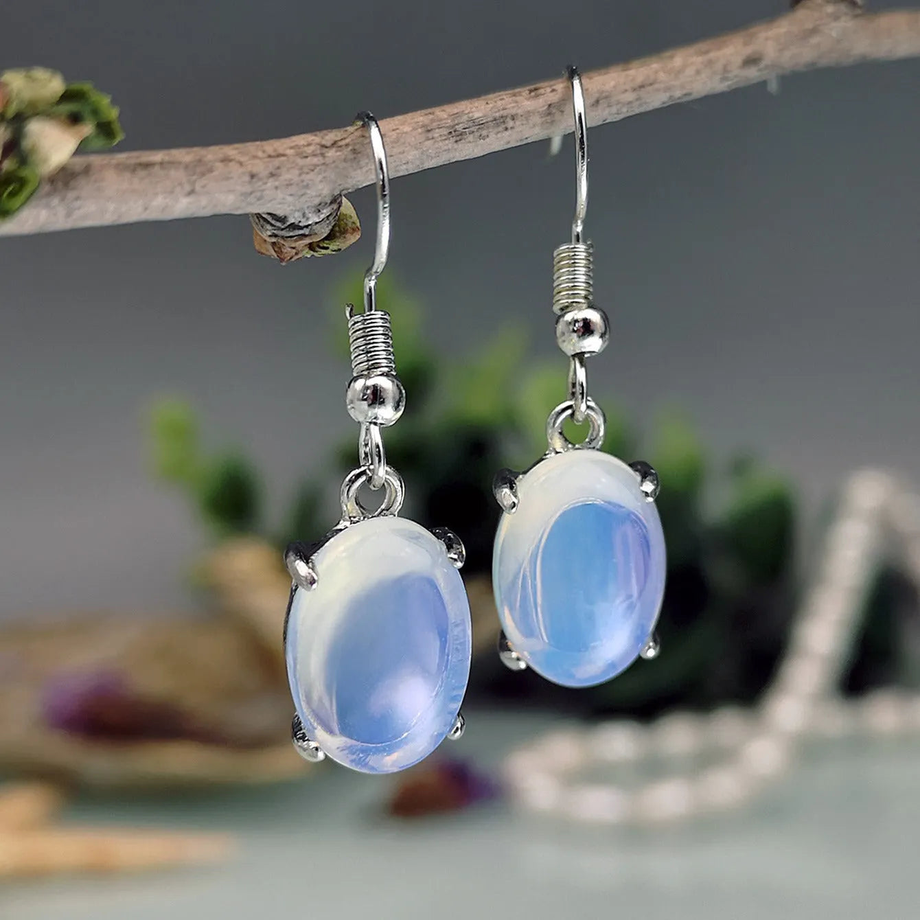 Opal earrings with retro moonstone aesthetic, cross design and ellipse pendant in drop shape