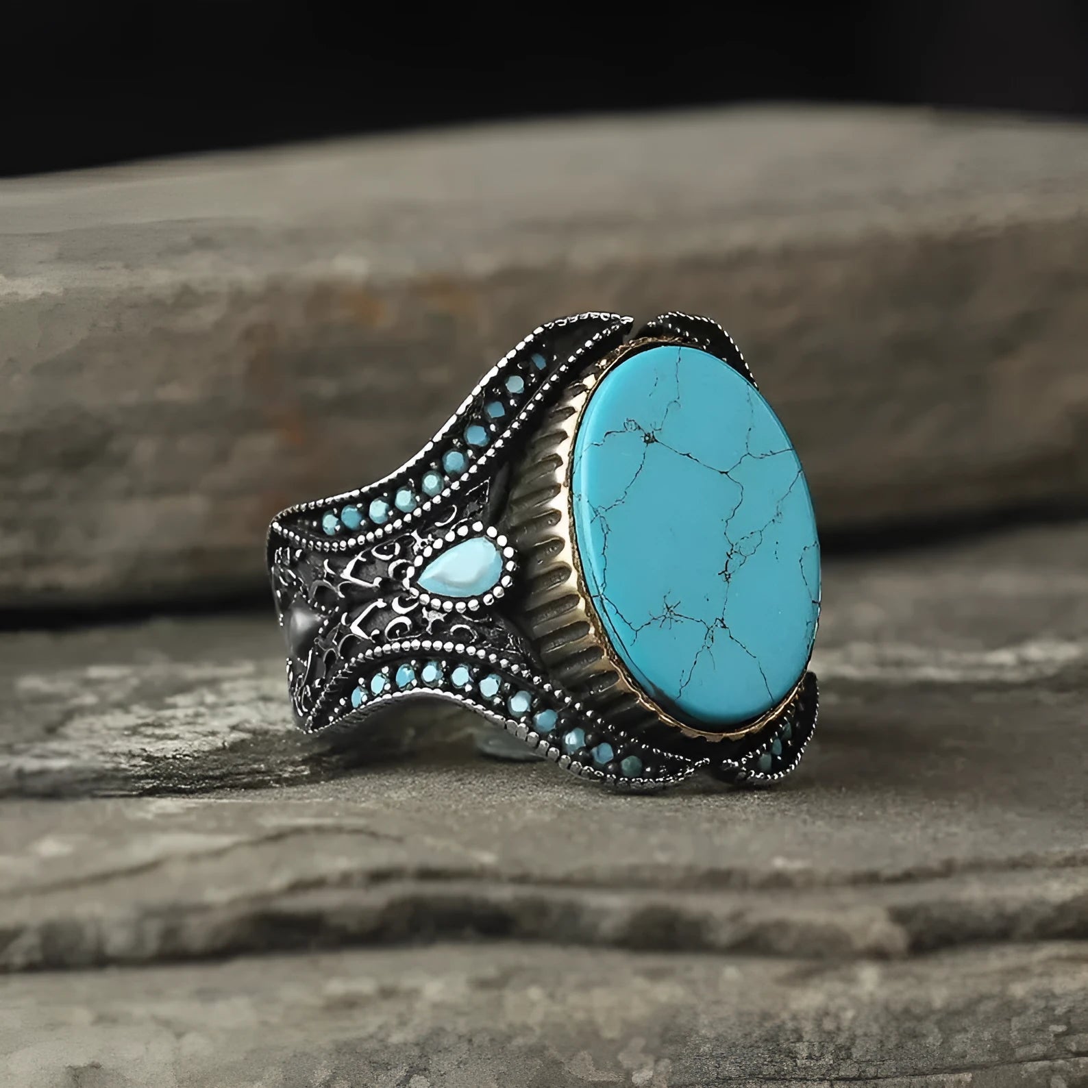 Men's antique silver alloy ring with a round shape and turquoise-coloured centrepiece on a grey background.