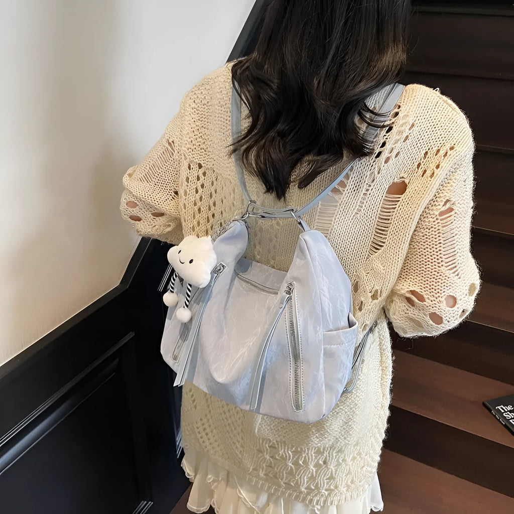 Women's soft PU leather fashion backpack in black, white, silver, or blue colour with pendant accessory