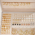 108 gold and yellow geometric alloy earrings with round bead details laid out flat.