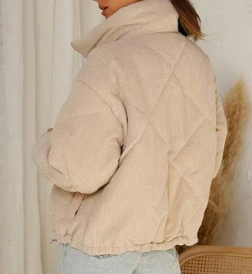 Apricot coloured women's corduroy zip jacket with stand collar and long sleeves on a hanger.