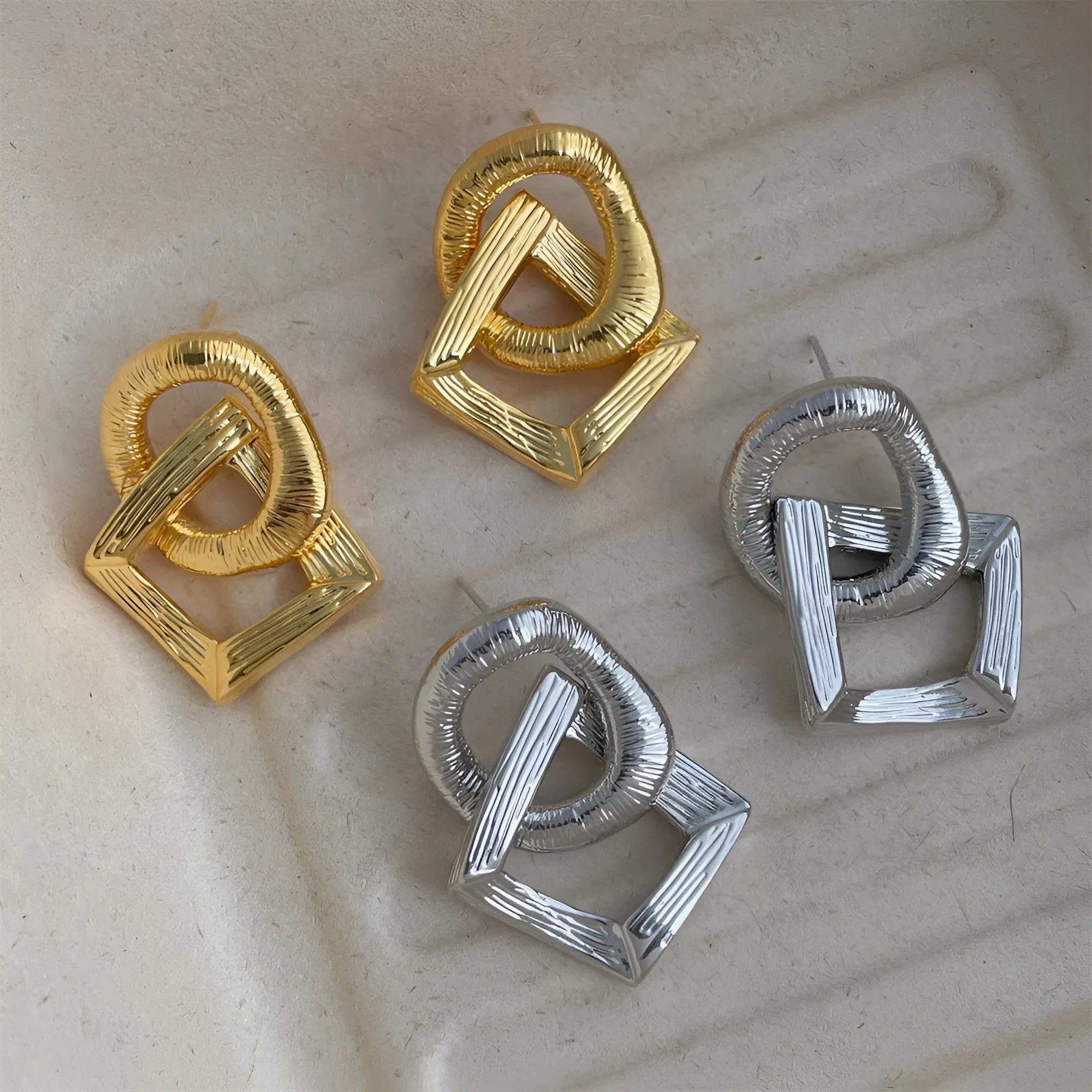 Gold and silver geometric circle pendant earrings with a 3.4cm drop length on a white background.
