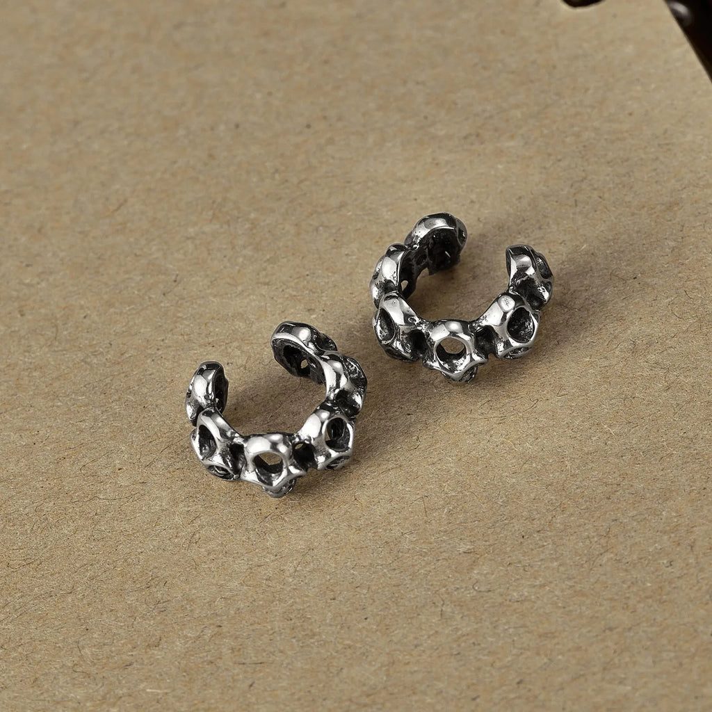 Stainless steel hollow skull ear clips with geometric design and steel colour finish