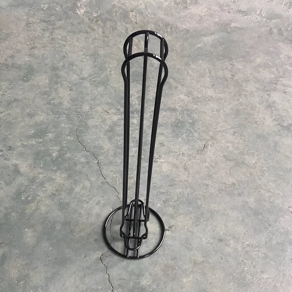 Black wrought iron coffee capsule storage rack holding 20 pods on display shelves.