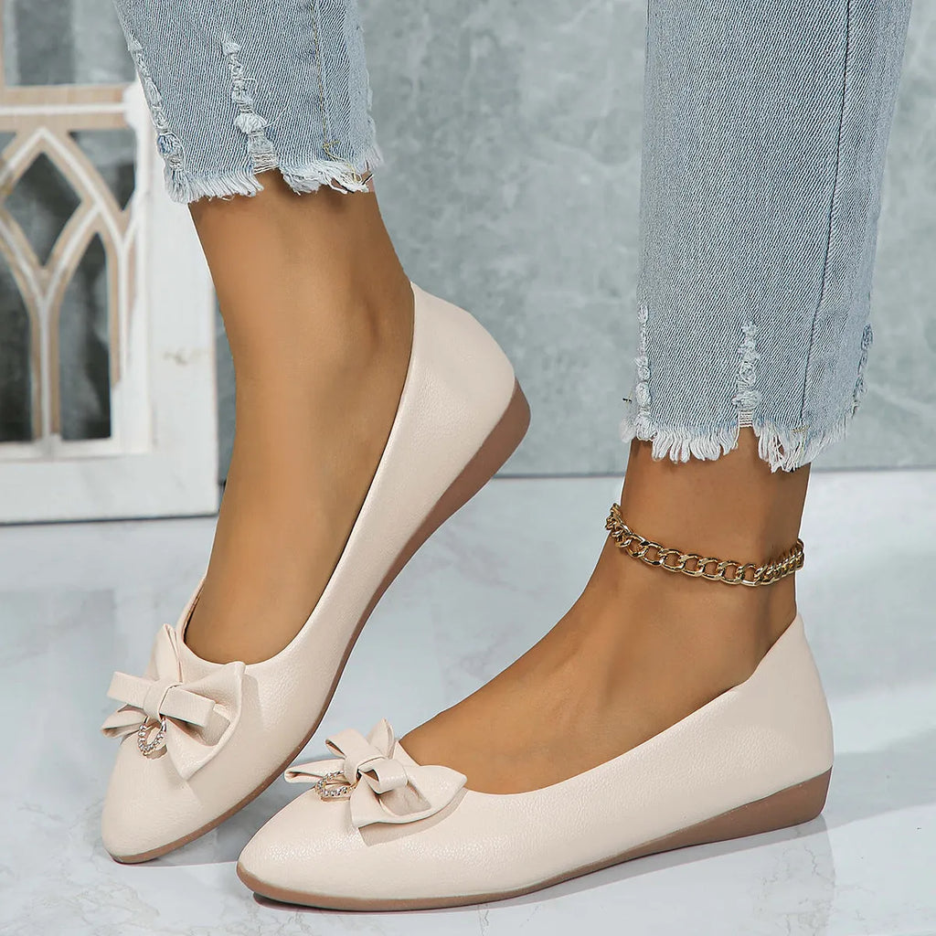 Women's beige flat casual shoes with a bowknot and shallow mouth design on a white background.