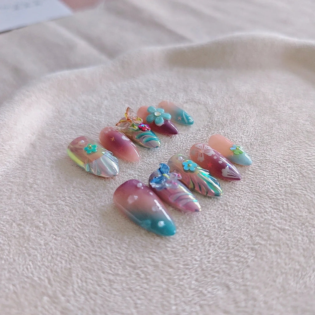 Handmade colourful false nails with 3D embossed flowers and butterflies on almond-shaped nails