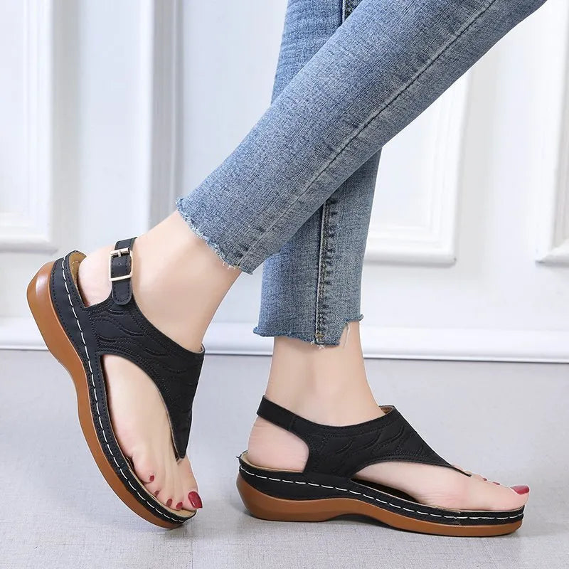 Women's wedge heel sandal in a solid colour with an adjustable back strap buckle.