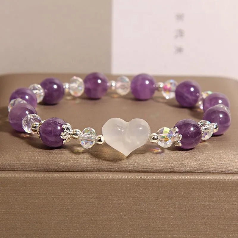 Natural amethyst bracelet with white agate love heart charm on a light background