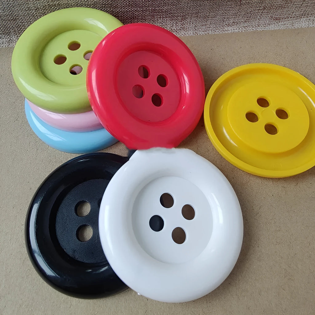 Assortment of oversized round plastic buttons in multiple colours with four holes.