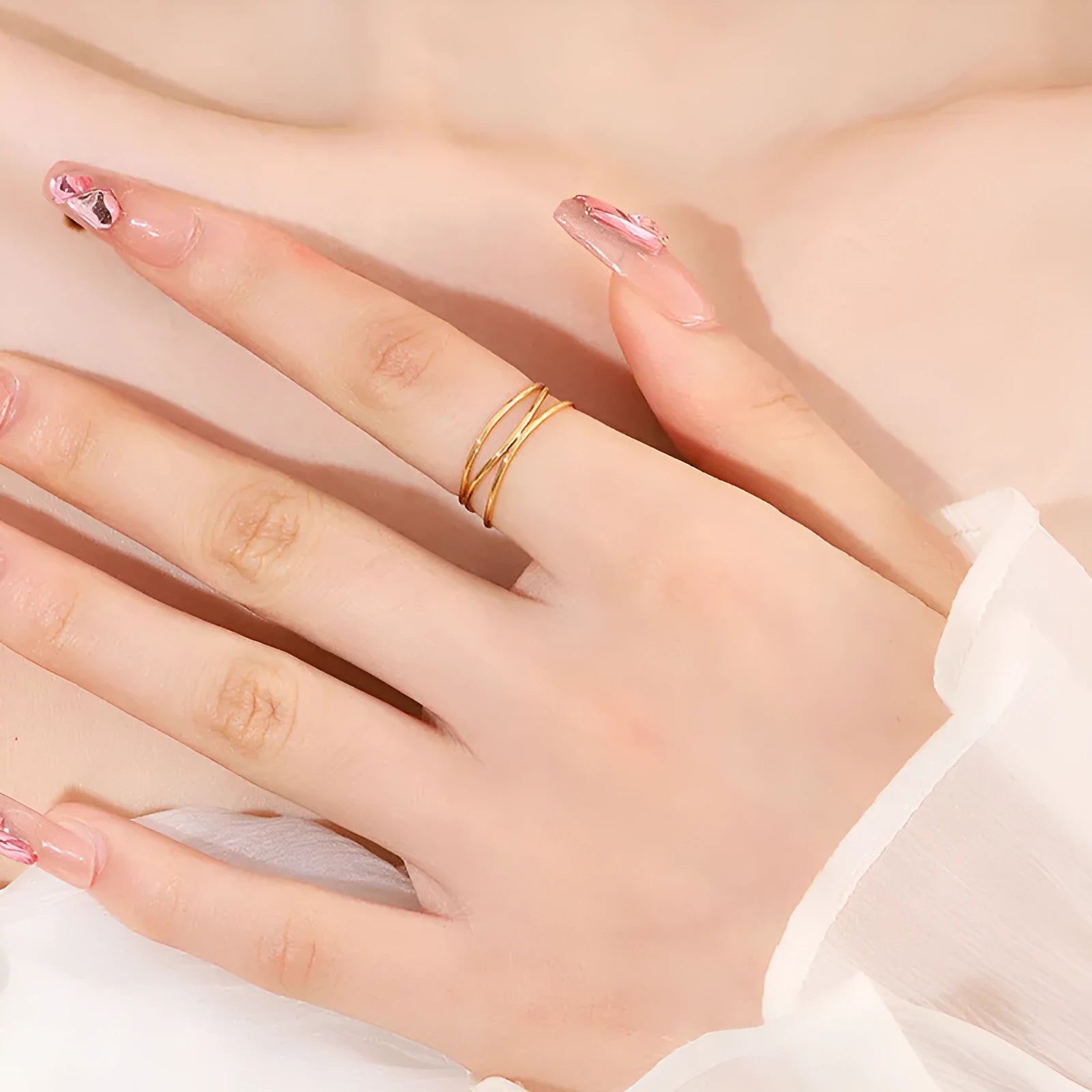 Gold titanium steel women's ring with a three-layer geometric line and coiled design on a white background.