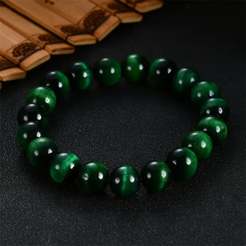Green Tiger Eye stone bracelet with polished geometry beads on a wrist.