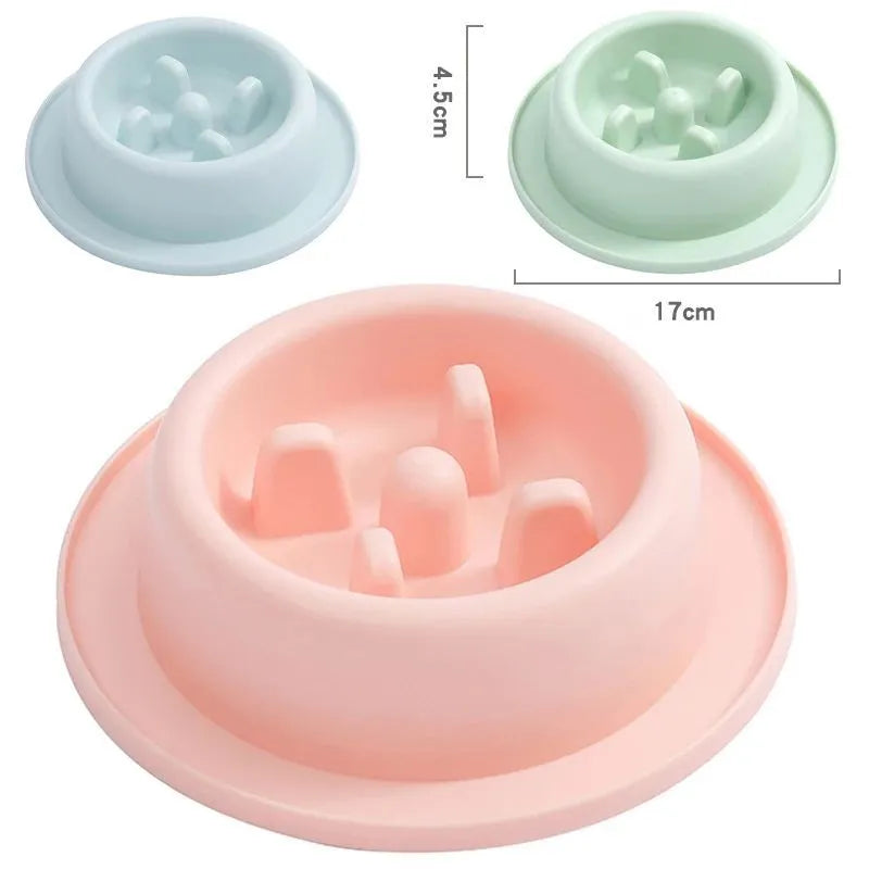 Pink pet slow feeder bowl with raised maze pattern and non-slip base on a floor
