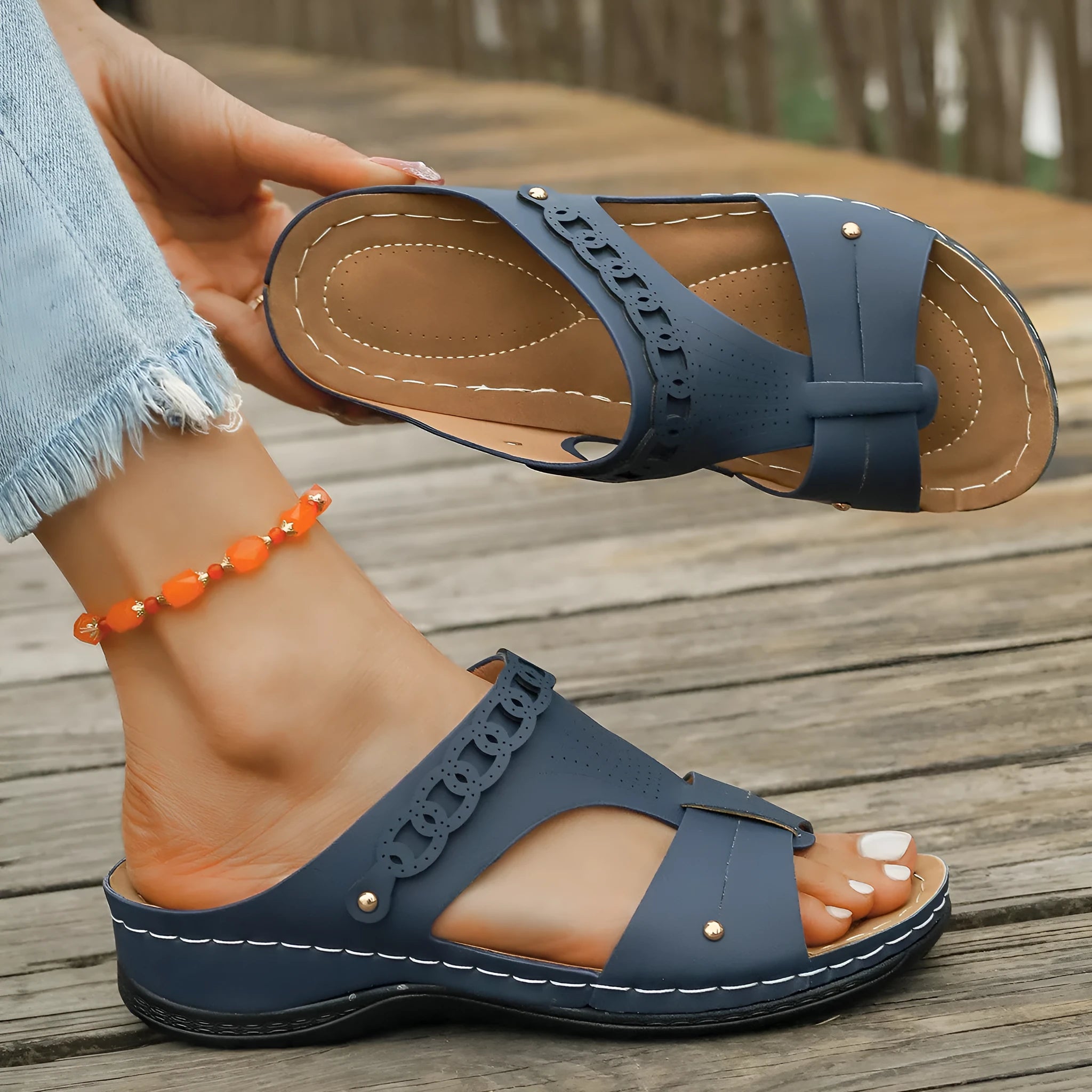 Pair of blue Roman-style slope heel slippers showing fish mouth toe holder design.