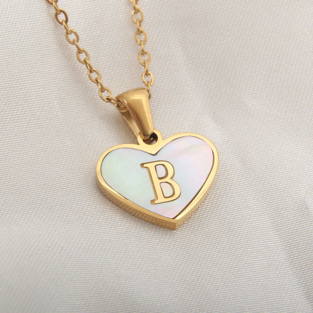 Gold-plated heart necklace with white shell pendant and initial personalisation on a stainless steel chain.