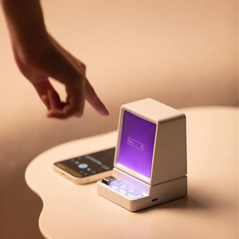 Light grey portable Bluetooth speaker shaped like a classic computer on a desk