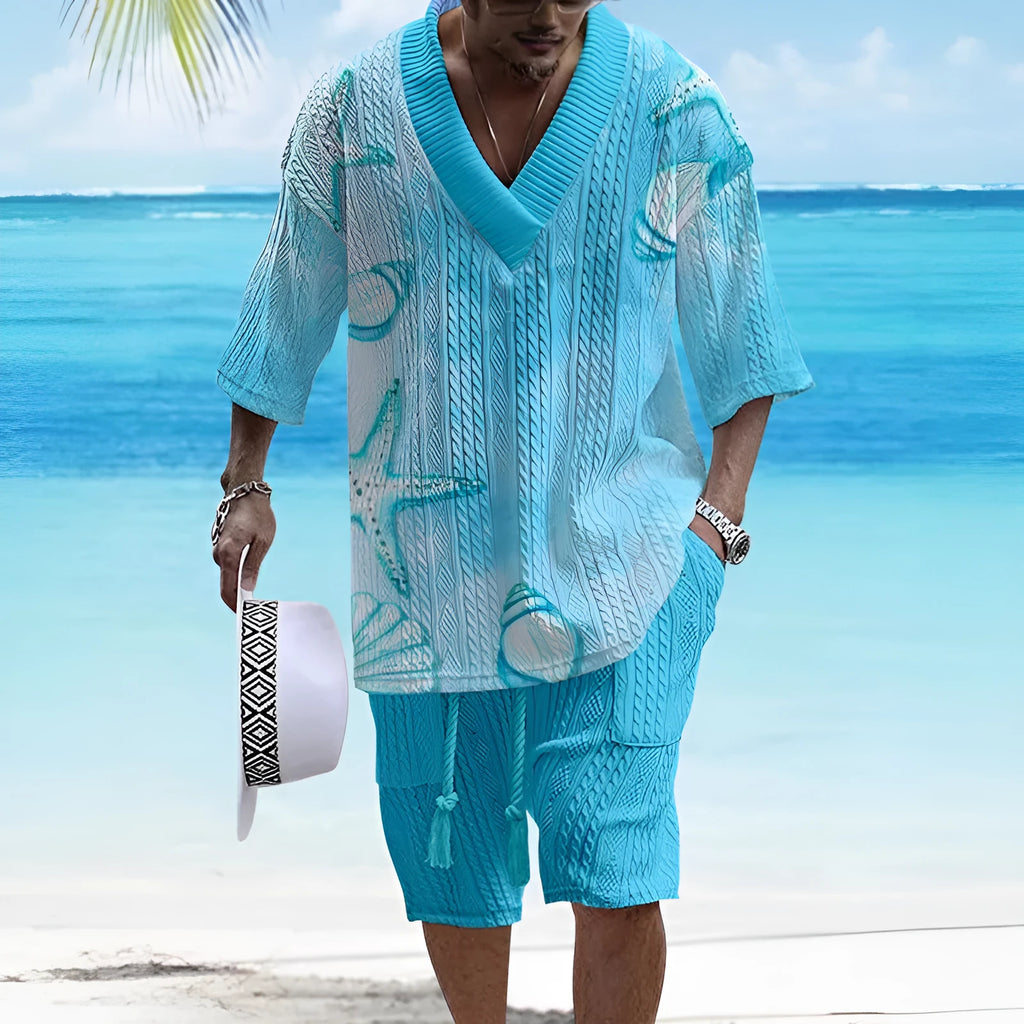 Man wearing a loose-fitting light blue short sleeve suit top and matching shorts, a casual two-piece set.