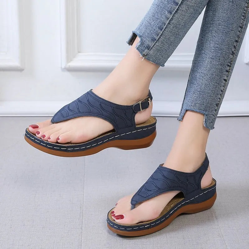 Women's wedge heel sandal in a solid colour with an adjustable back strap buckle.