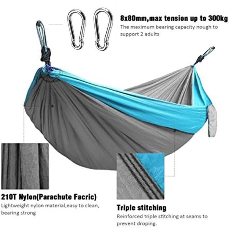 Blue parachute nylon outdoor camping hammock hung between two trees.