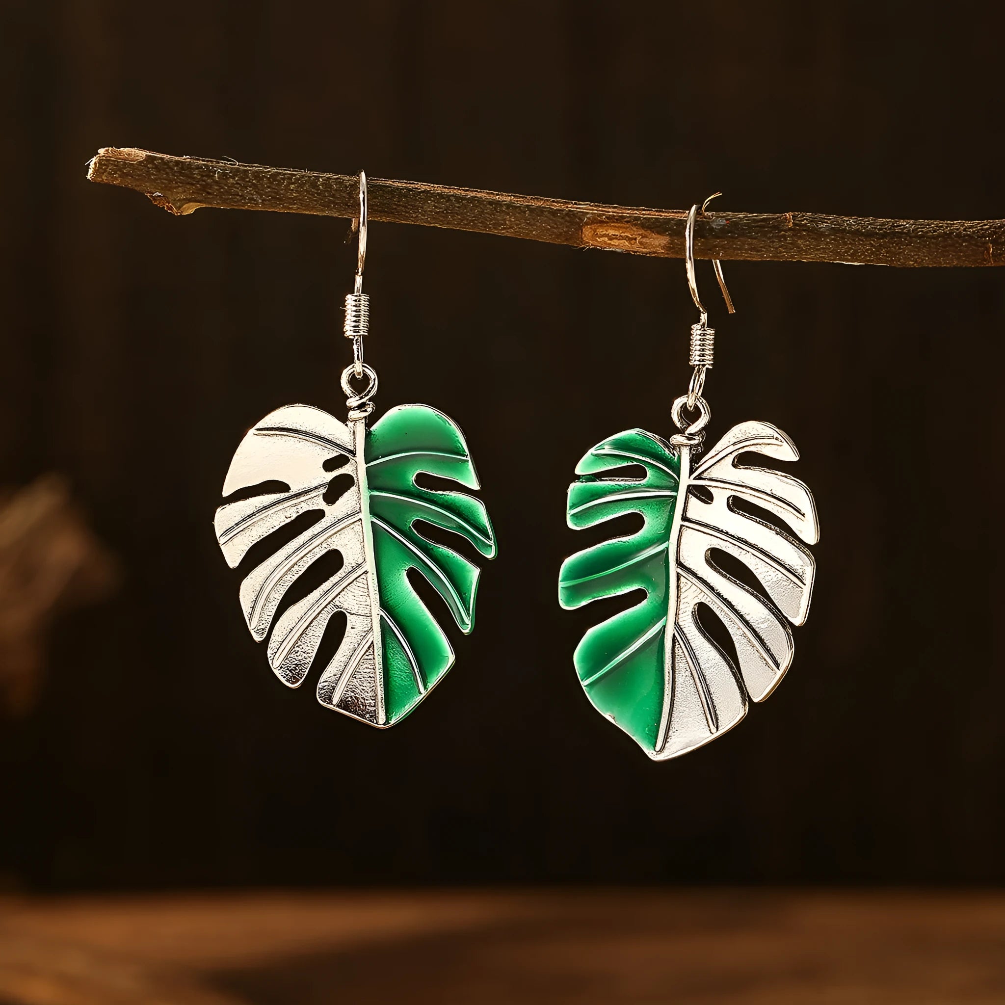 Silver alloy leaf-shaped drop earrings for women on white background