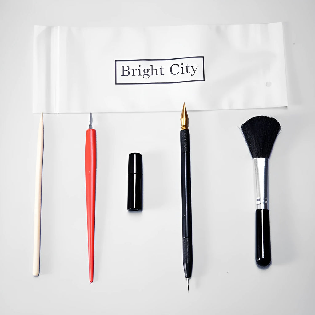 Scratch painting tools set with white card, 14.5cm long tool, brushes, and photo frames on a table.