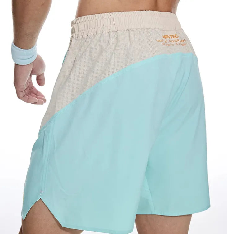 Man's loose grey workout shorts with elastic waist and white lace-up fly front.