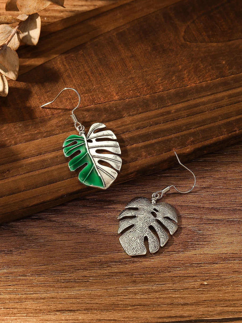 Silver alloy leaf-shaped drop earrings for women on white background