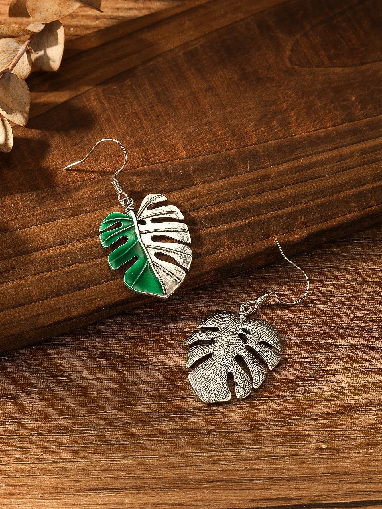 Silver alloy leaf-shaped drop earrings for women on white background