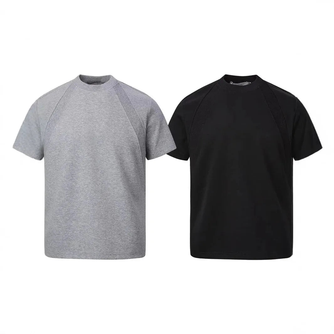 Men's loose black short sleeve top with textured air layer stitching on a grey background