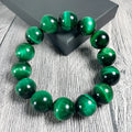 Green Tiger Eye stone bracelet with polished geometry beads on a wrist.
