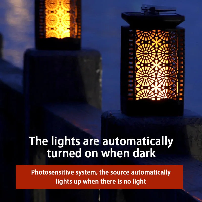Grey retro-style solar lawn light with flame effect LED, placed in a garden.