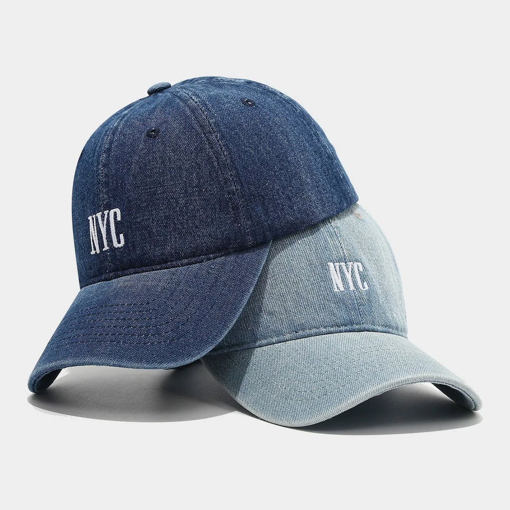 Light blue denim baseball cap with dome crown and printed alphabet letters on the front.